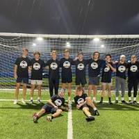 Students wearing championship shirts from a men's soccer tournament